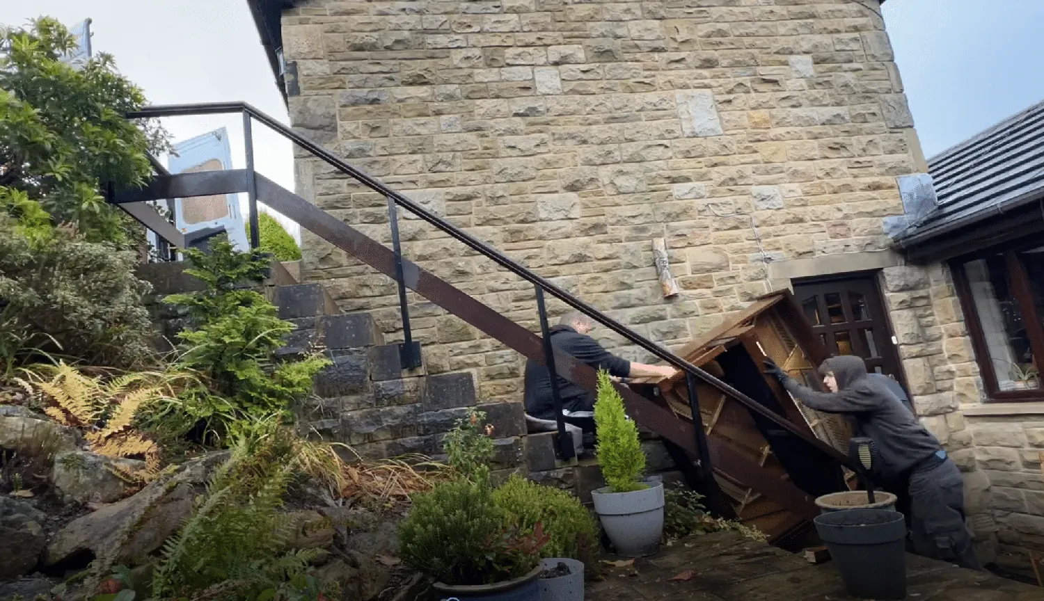 Moving a grand piano down external stone steps for disposal
