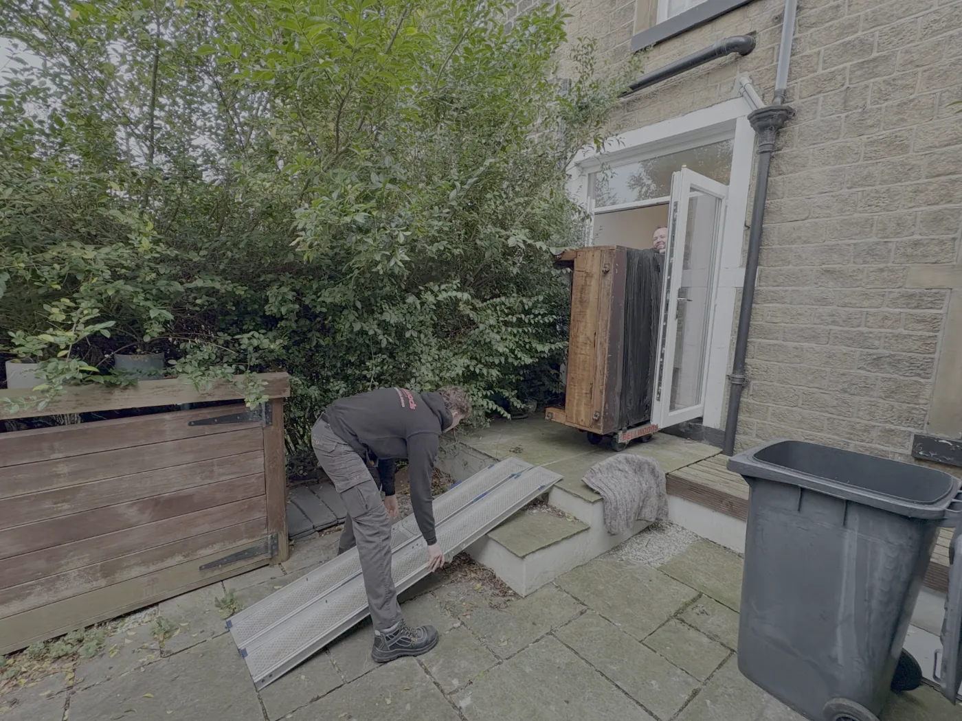 Our team carrying a piano down external steps on a ramp for disposal in West Yorkshire