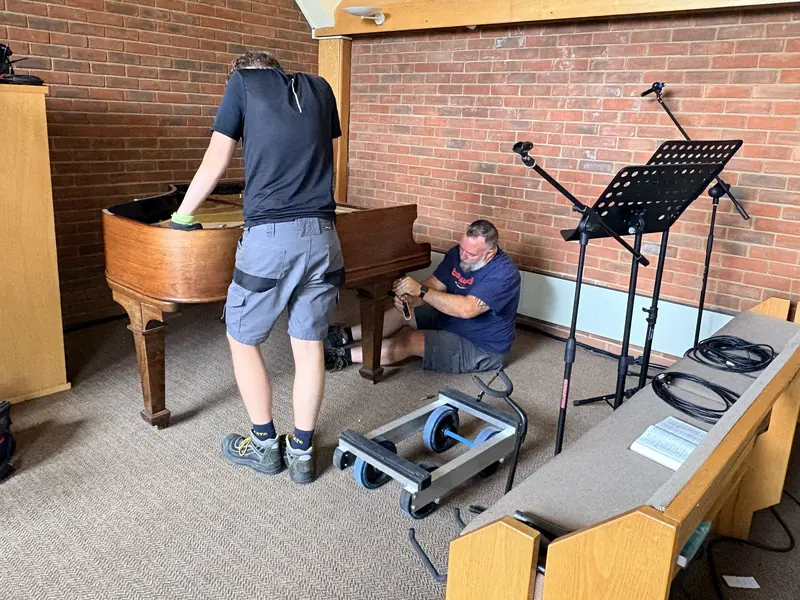 Taking the pedal lyre off a grand piano in a Sheffield church before removing it for disposal
