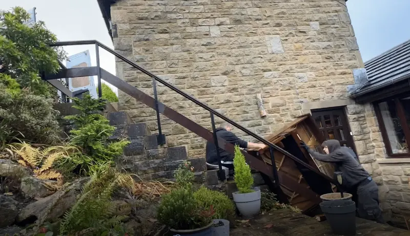 Moving a grand piano down external stone steps for disposal