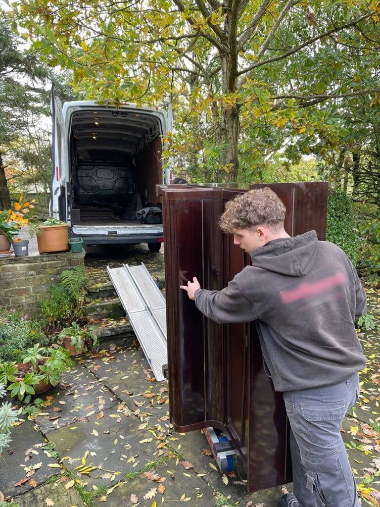 Loading piano in to removal van for disposal