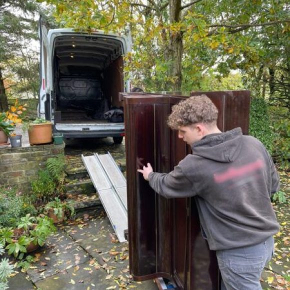 Loading piano in to removal van for disposal